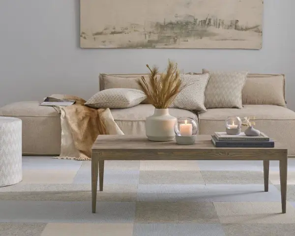 Gemütliches, **ästhetisches Zimmer** mit beigem Sofa, Holztisch, Kerzen und Deko.