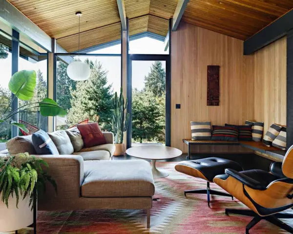 Gemütliches Wohnzimmer im **mid century modern** Stil mit großen Fenstern, Holzdecken und einer gemütlichen Sitzecke.