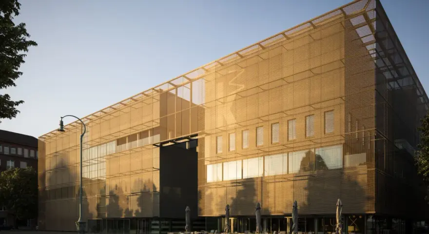 Moderne Architektur der Kunsthalle Mannheim im goldenen Abendlicht. Vor dem Gebäude laden Tische und Stühle zum Verweilen ein.