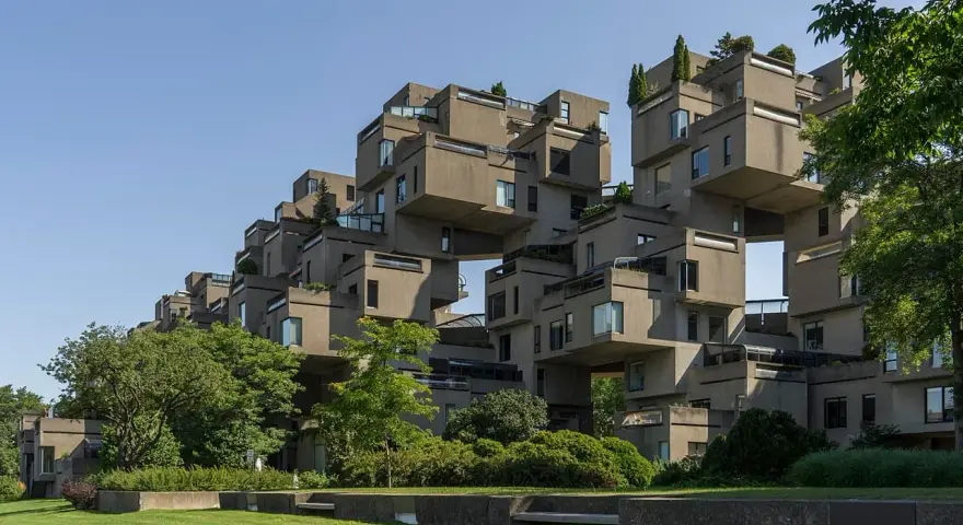 Ein beeindruckendes Beispiel brutalistischer Architektur: Betonblöcke stapeln sich zu einer futuristischen Wohnanlage, umgeben von Grün.