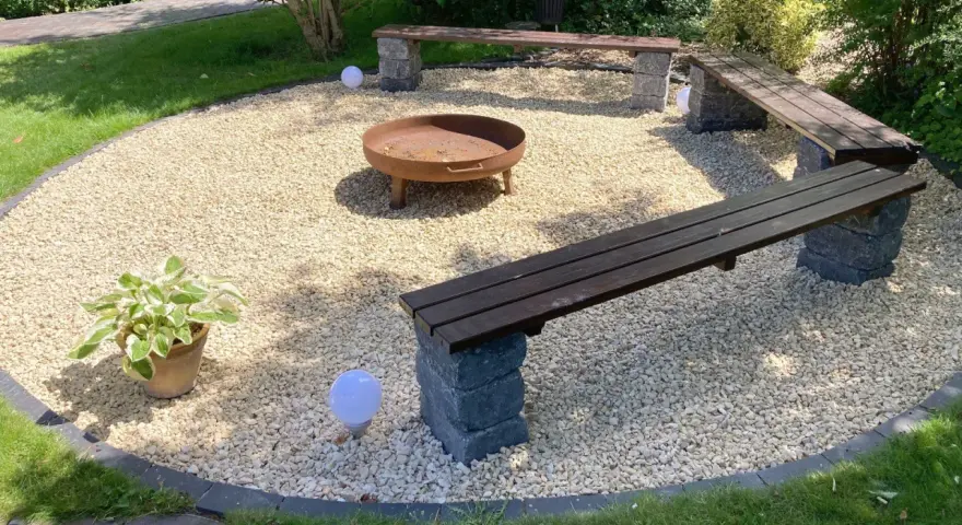 Gemütliche Kies Garten Sitzecke mit Feuerstelle und Bänken. Perfekt für laue Sommerabende.