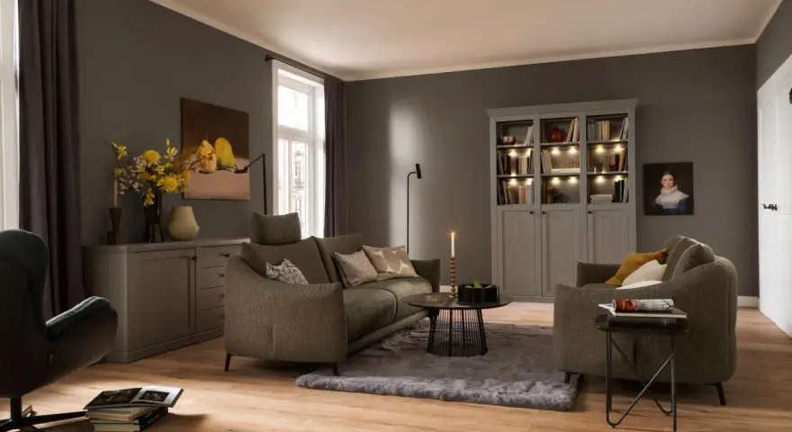 Gemütliches Wohnzimmer mit einem weichen, grauen Teppich unter dem Sofa und einem Sessel.
