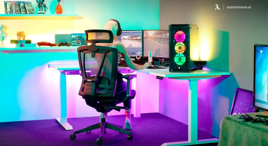 Kleine Gaming-Zimmer-Ideen: Ein Spieler genießt bunte Beleuchtung und zwei Monitore.