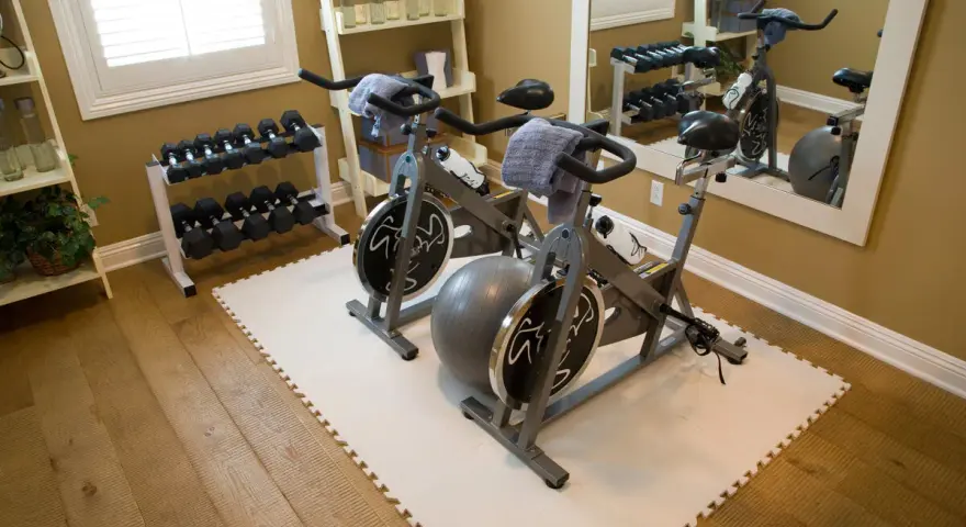 Zwei Heimtrainer, Hanteln und ein Gymnastikball – tolle home gym ideen für dein Workout zu Hause.