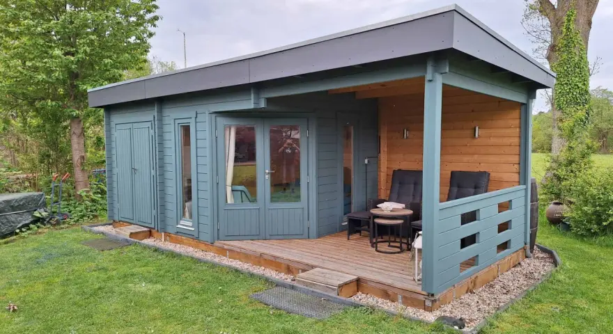 Ein blaugrünes Gartenhaus mit Veranda und Sitzgelegenheiten. Tolle Gartenhaus Farben Ideen für Ihr grünes Paradies.