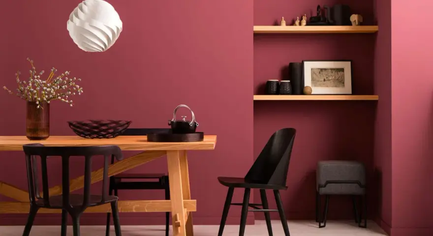 Esszimmer mit Holztisch, schwarzen Stühlen und Wandfarbe Beere kombinieren. Ein moderner Look, der Gemütlichkeit ausstrahlt.