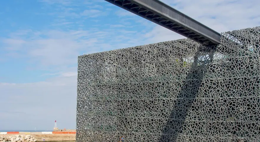 Das MuCEM Marseille mit seiner faszinierenden Gitterfassade, die wie ein Netz wirkt, ragt am Hafen auf.