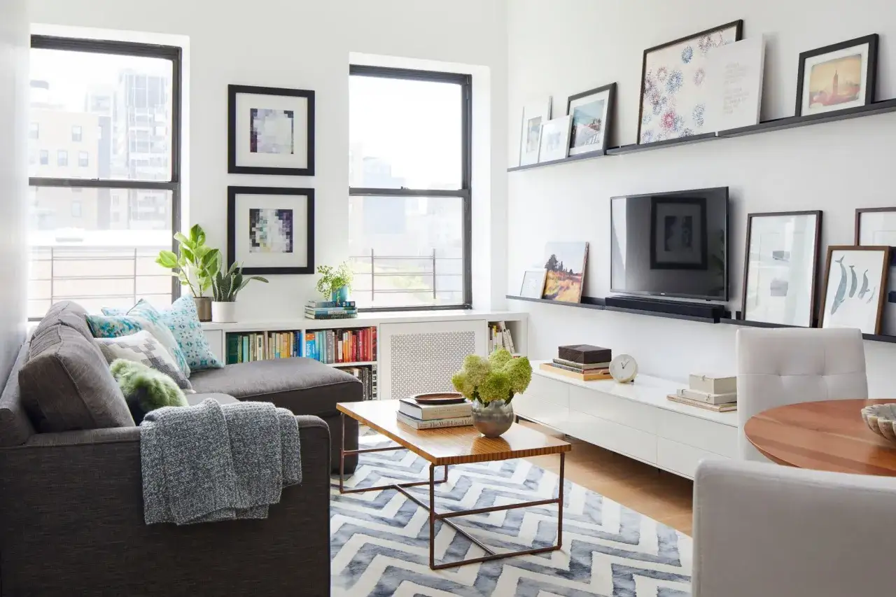 Gemütliche 1 Zimmer Wohnung einrichten 30qm: Sofa, Couchtisch, TV-Möbel, Bilder & Bücherregal schaffen ein stilvolles Zuhause.