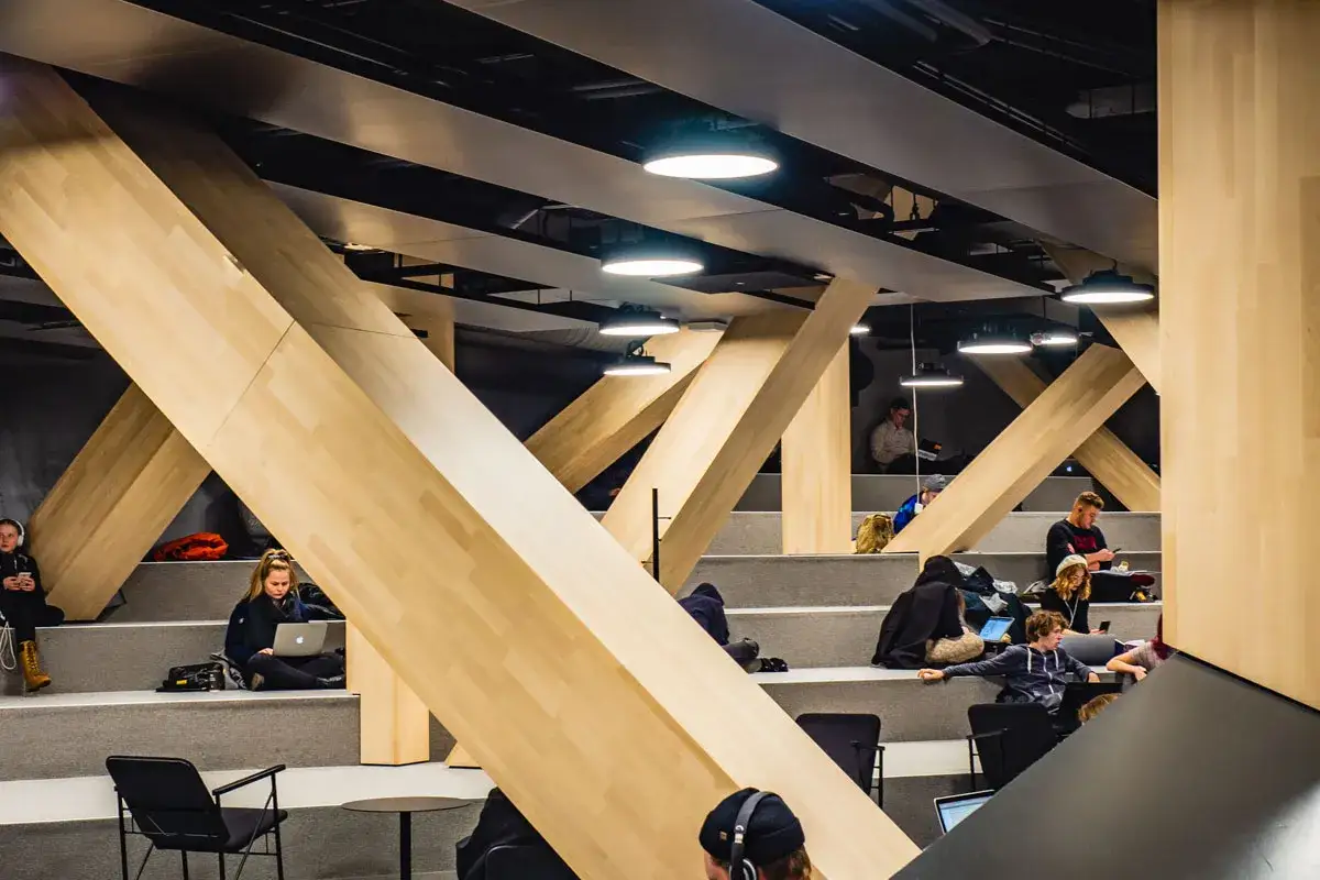Studierende lernen und arbeiten in der modernen Architektur der Oodi Helsinki Bibliothek.