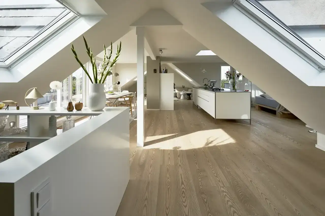 Moderne K&uuml;che und Wohnbereich im ausgebauten niedrigen Dachboden mit viel Licht durch Dachfenster.
