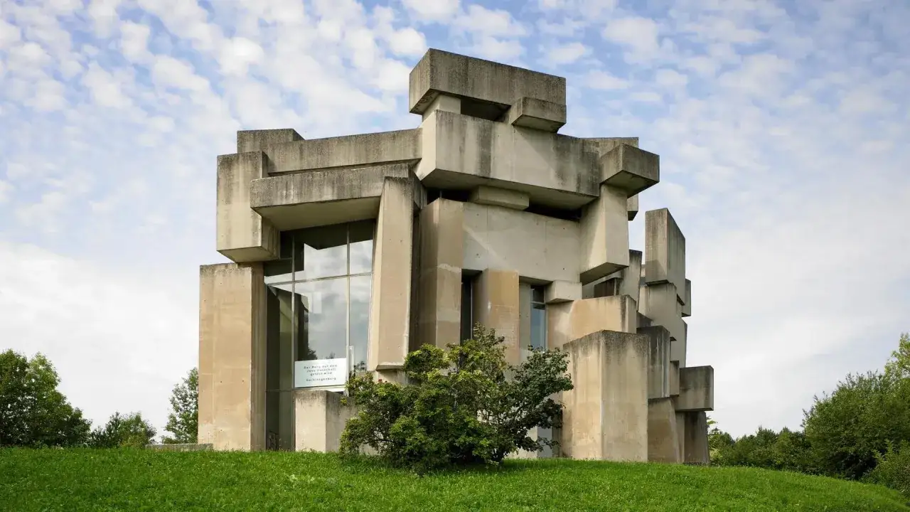 Monumentales Geb&auml;ude in brutalismus architektur, mit Betonbl&ouml;cken und Glasfronten, umgeben von Gr&uuml;nfl&auml;chen und B&auml;umen.