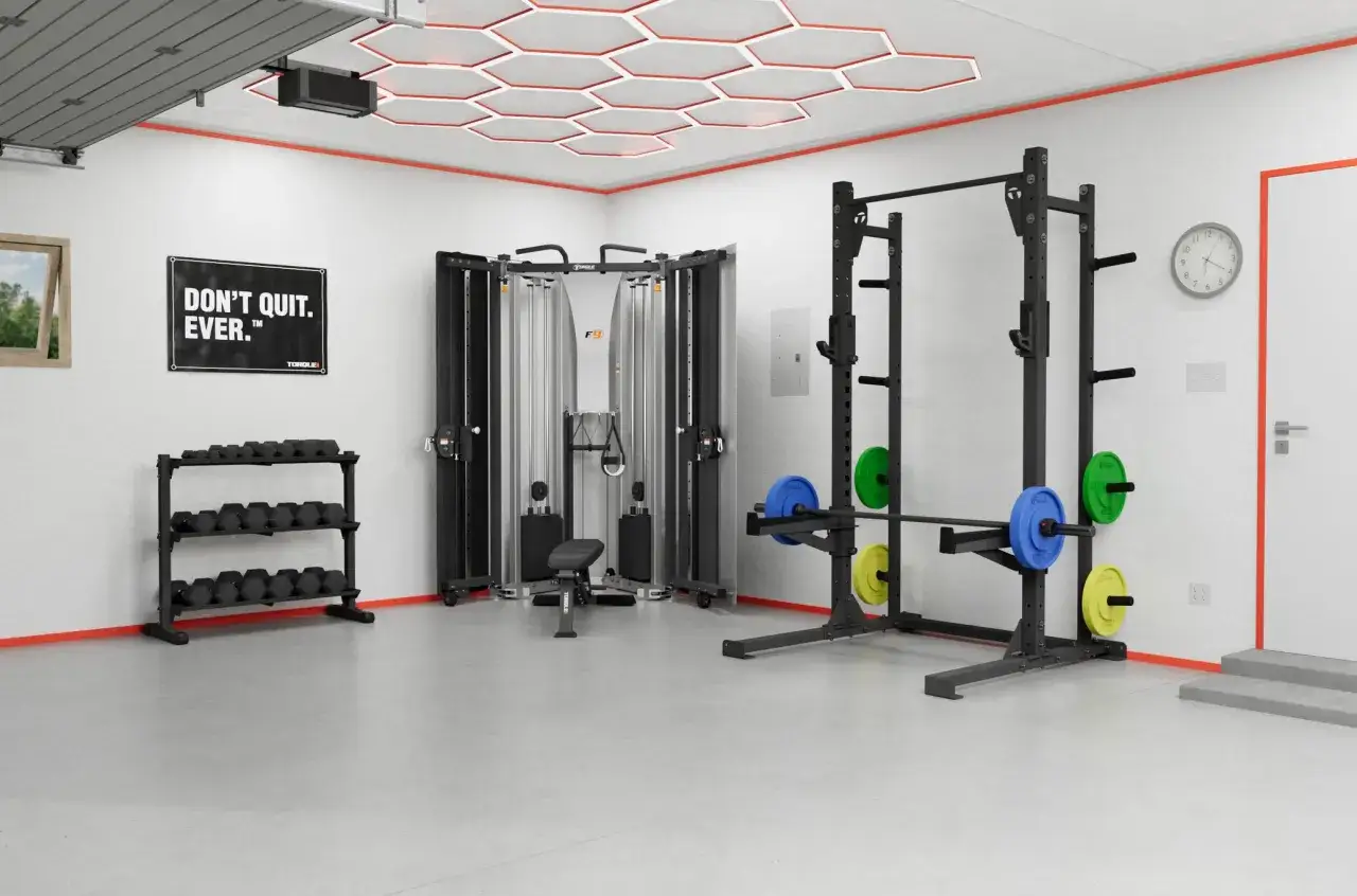 Moderne Garage-Fitnessstudio-Ideen: Hantelständer, Kabelzugturm und Power Rack mit Gewichten. Motivierendes Poster an der Wand.