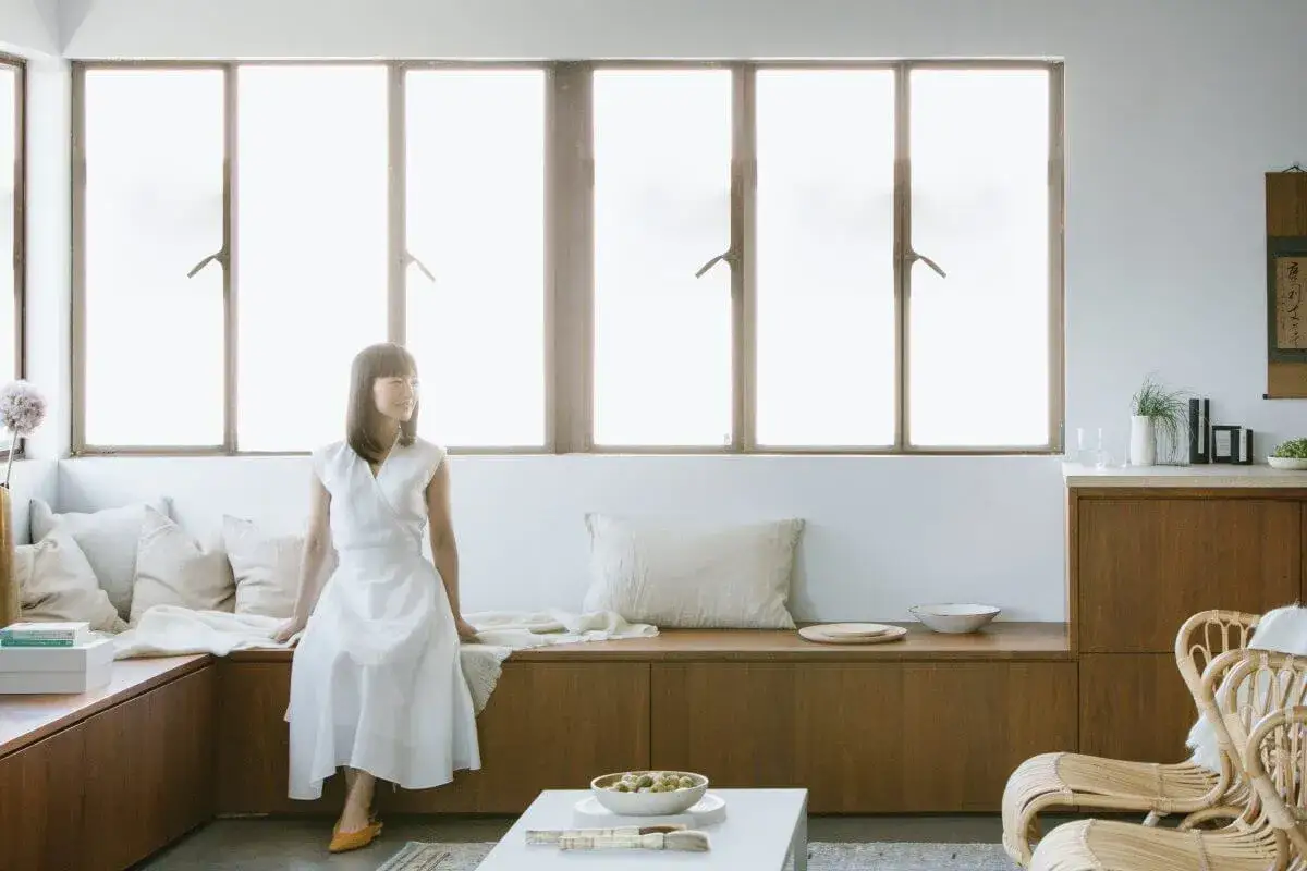 Marie Kondo sitzt in einem hellen Raum, der die Marie Kondo Methode verkörpert: aufgeräumt und minimalistisch.