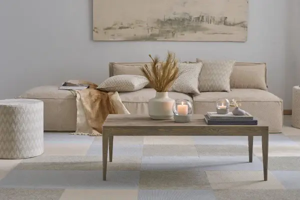 Gemütliches, **ästhetisches Zimmer** mit beigem Sofa, Holztisch, Kerzen und Deko.